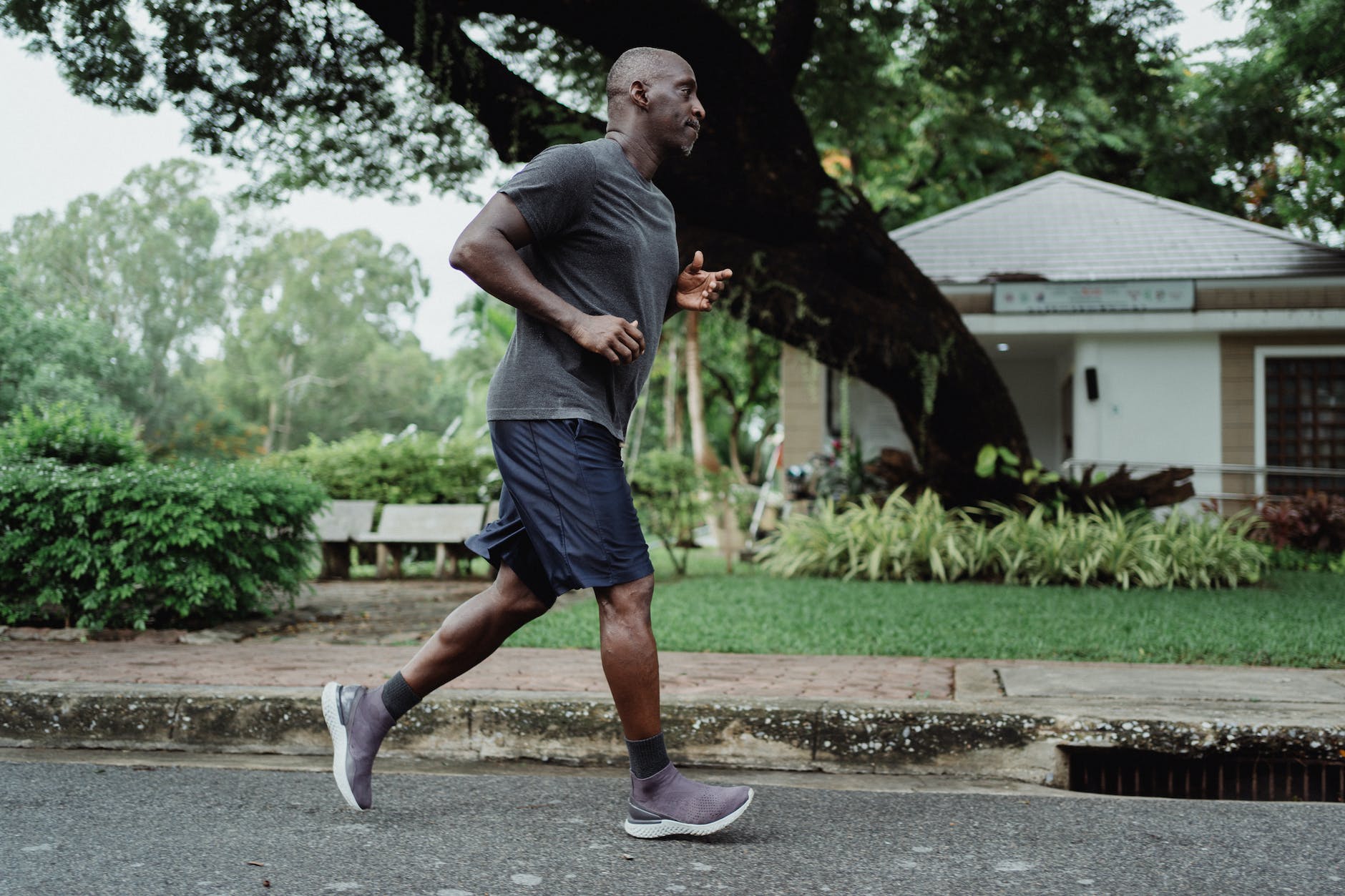 man in gray t shirt and black shorts running